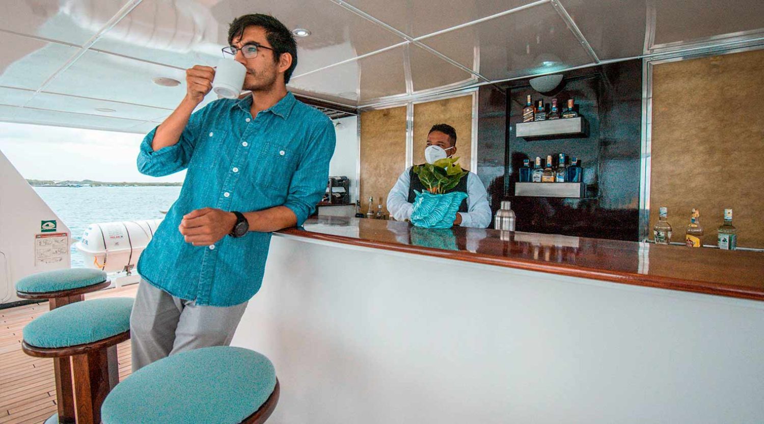 tourist in the bar of anahi catamaran yacht of galapagos islands