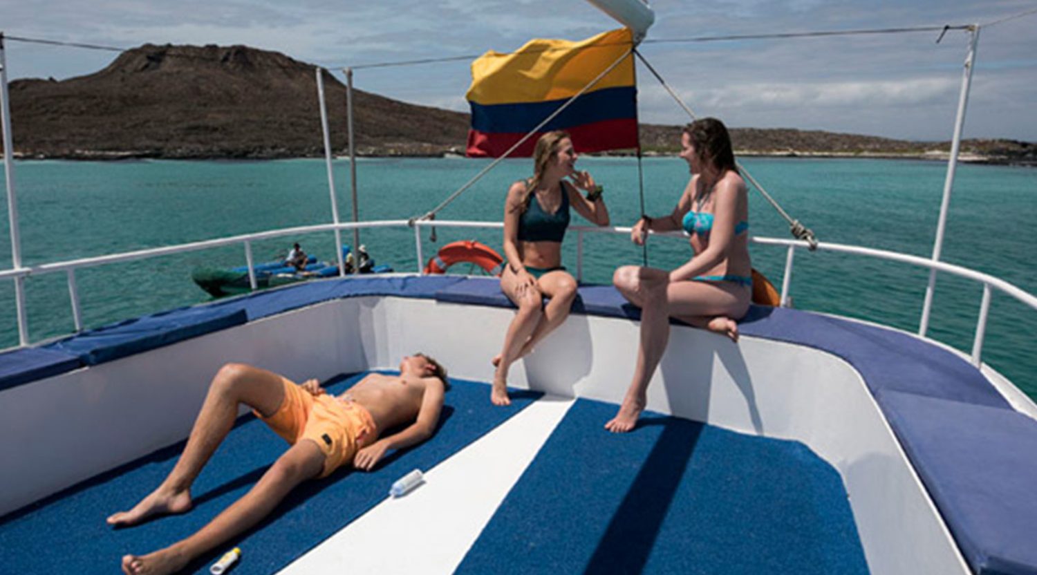 tourists getting tanned in the deck of golondrina yacht of galapagos islands