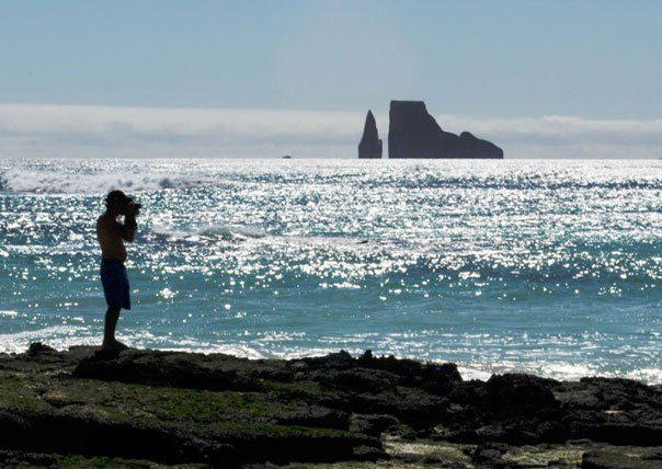 man taking a photo of kicker rock of galapagos islands tours