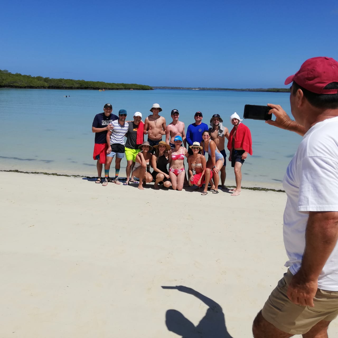 tourists taking a photo on tortuga bay in galapagos islands